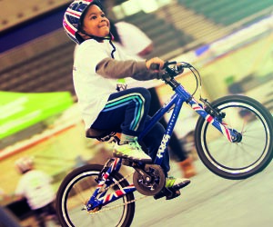 Frog Kids Bike in blue being ridden in a velodrome